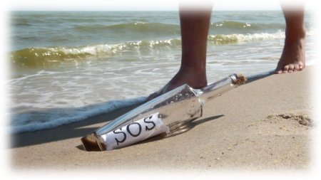 feet approaching bottle containing sos message on sandy beach