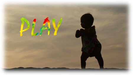 child on beach looking at a colourful word spelling play